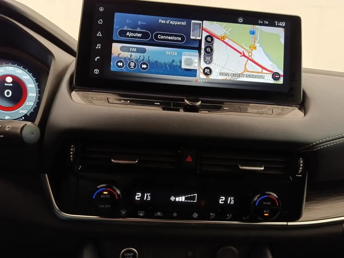 Vue intérieure du tableau de bord du Nissan Qashqai 2023 avec écran tactile 12,3 pouces et commandes climatisation digitales.