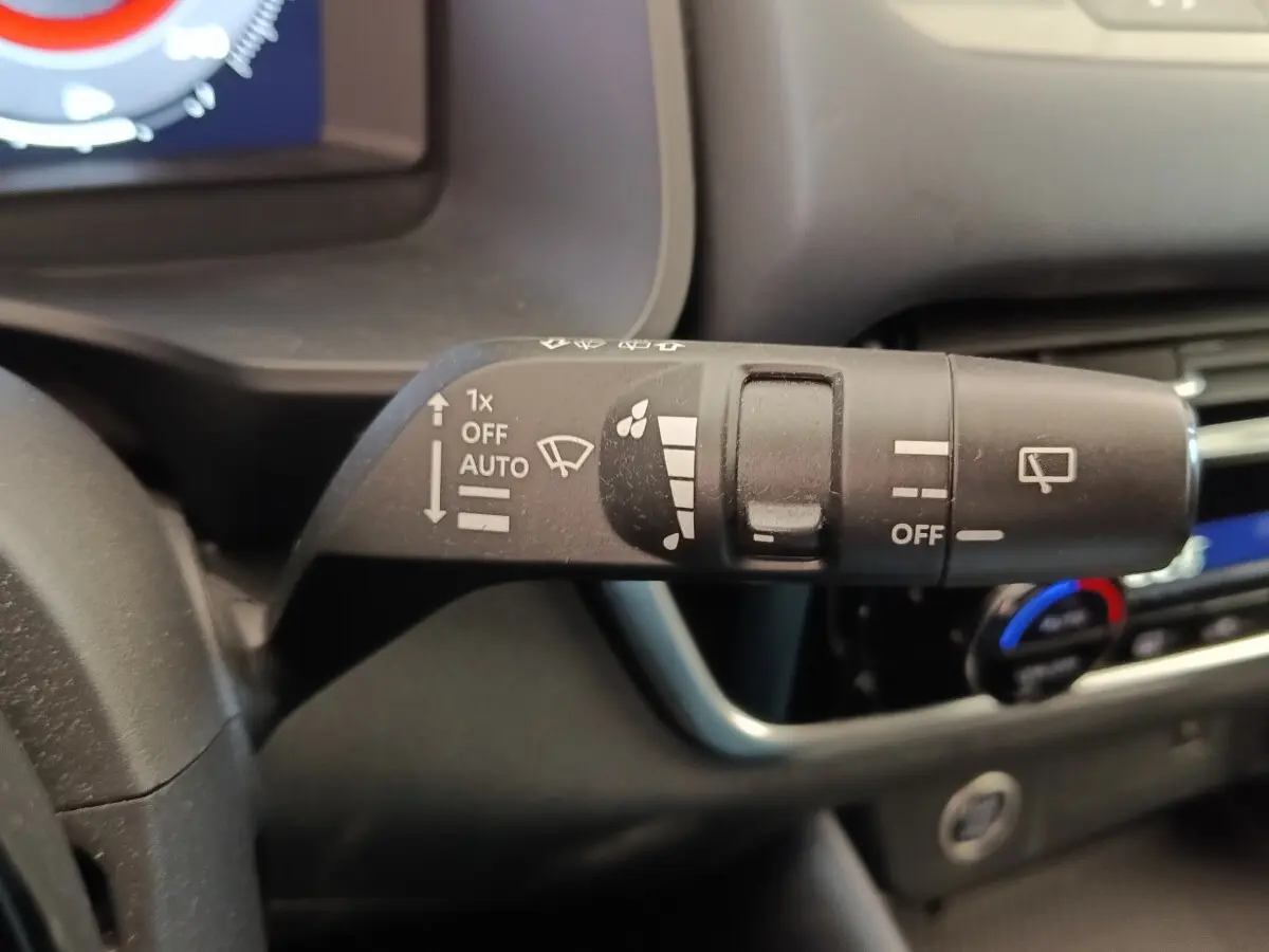 Gros plan sur la commande d’essuie-glace du Nissan Qashqai 2023, intérieur noir avec tableau de bord visible.