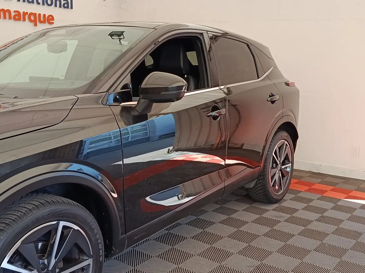 Vue de côté droit du Nissan Qashqai noir 2023, mettant en valeur les jantes alliage et les vitres teintées.
