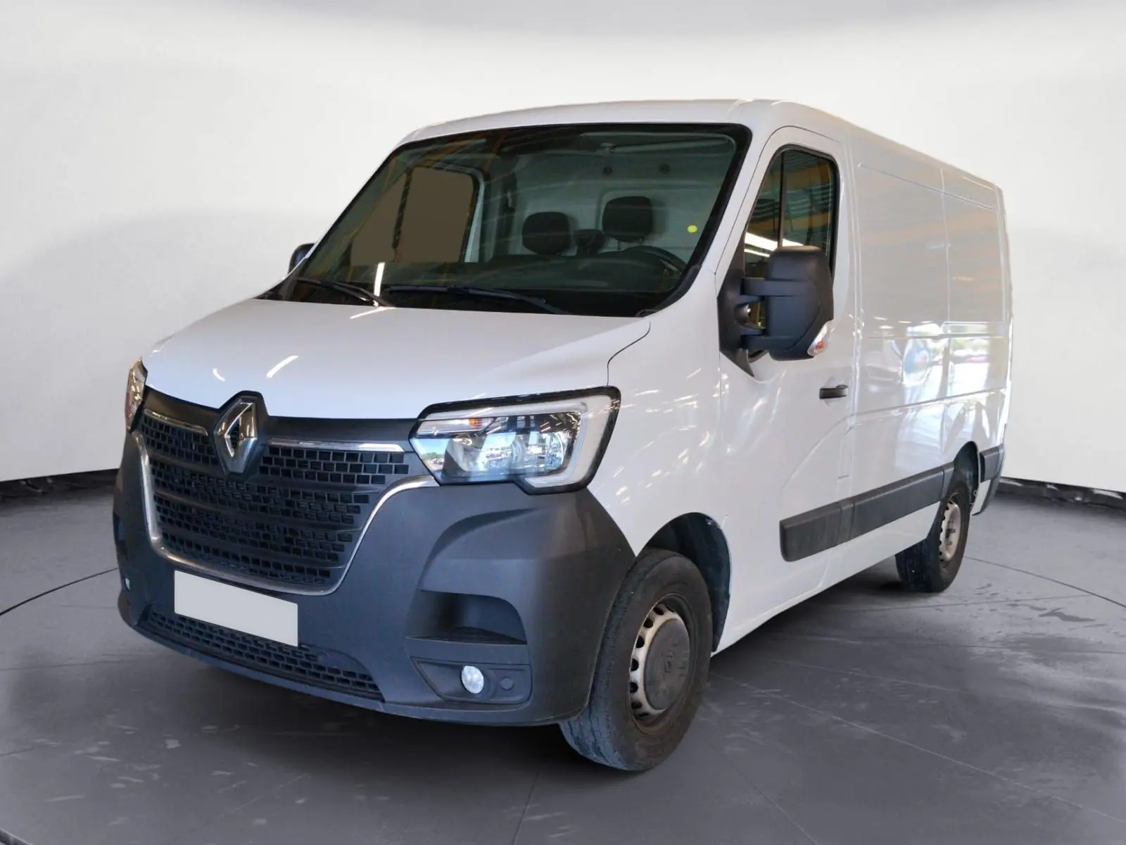 Vue 3/4 avant droit d’un Renault Master blanc 2023 avec pare-chocs noir et grandes surfaces vitrées sur portière.