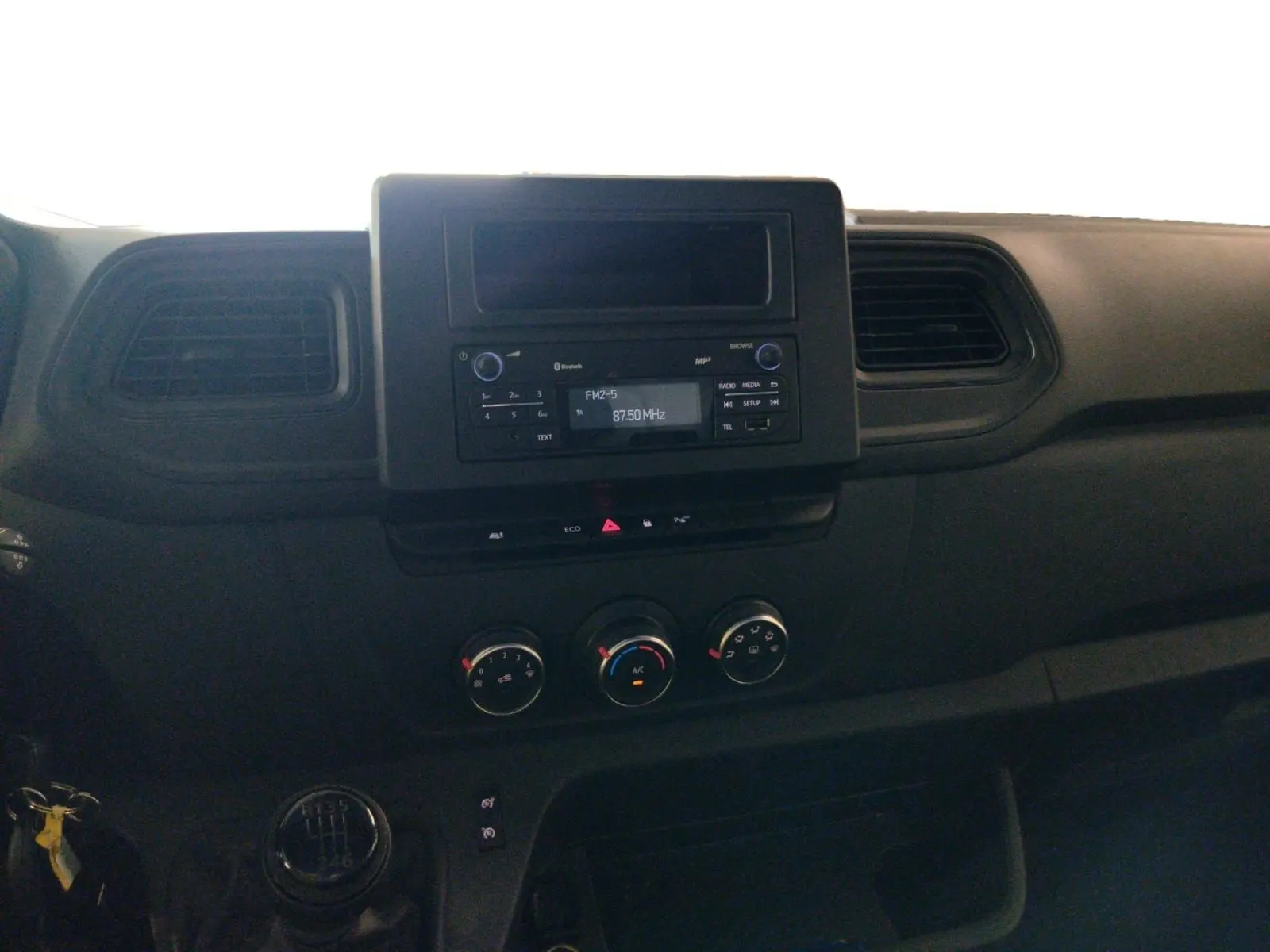 Vue intérieure du tableau de bord du Renault Master 2023, avec console centrale noire et commandes manuelles de climatisation.
