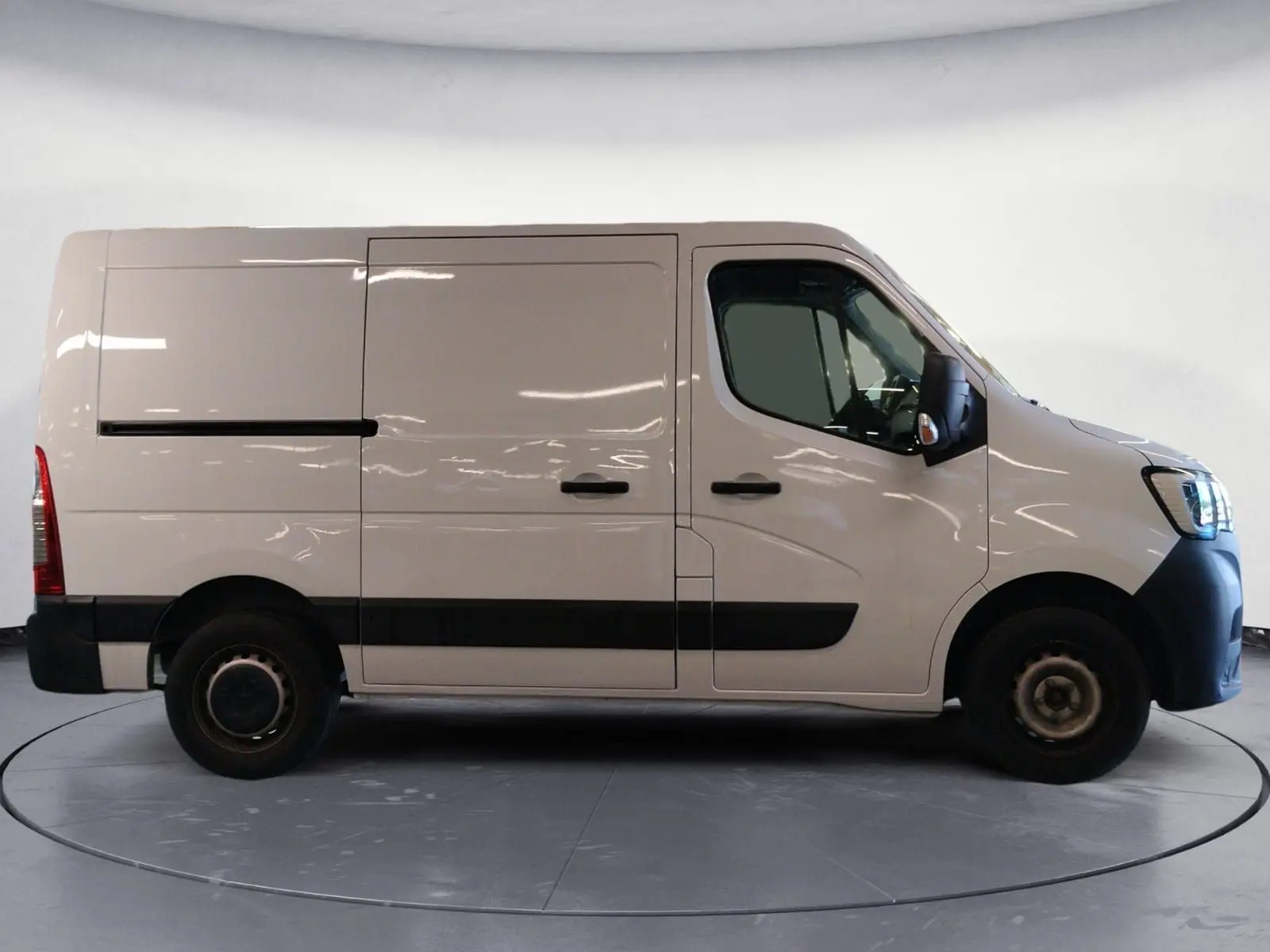 Vue latérale droite d’un Renault Master blanc 2023, fourgon utilitaire avec porte coulissante et protections noires sur les bas de caisse.
