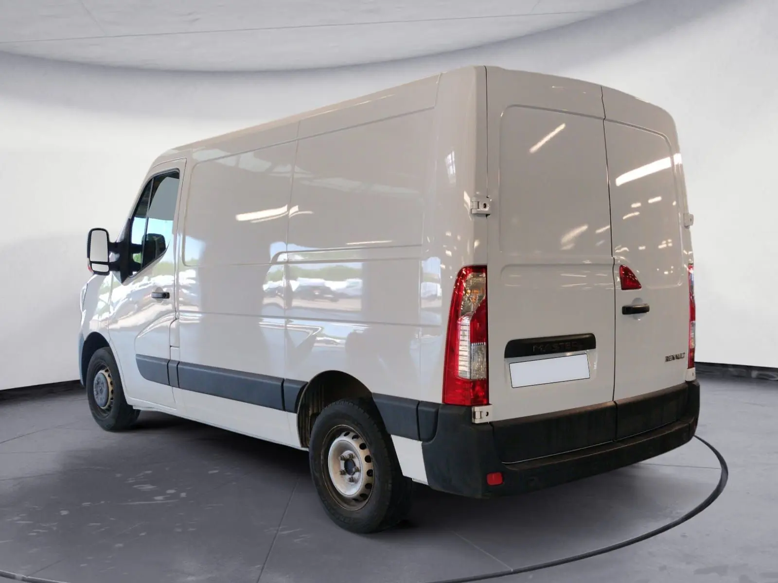 Vue 3/4 arrière droite d’un utilitaire Renault Master blanc avec portes arrière battantes et protections noires.
