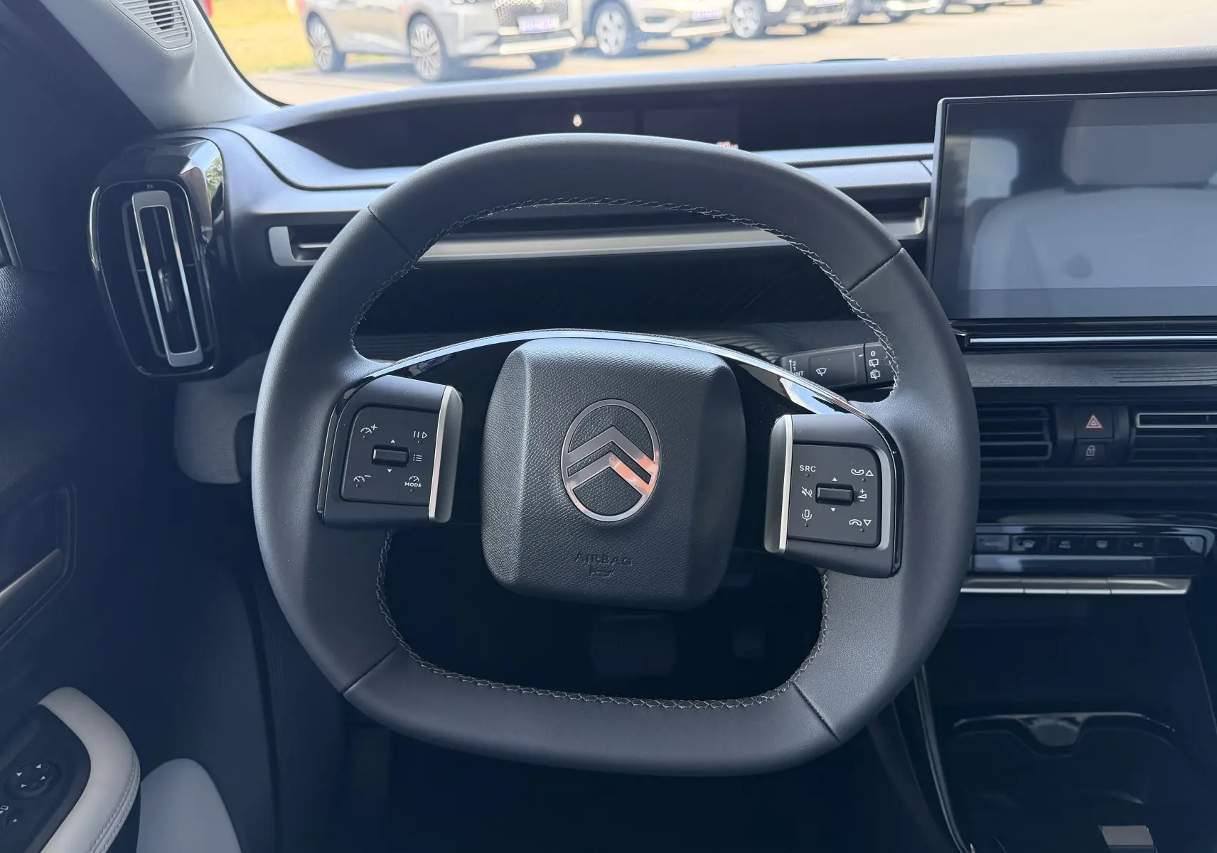 Vue intérieure centrée sur le volant noir de la Citroën E-C3 113 MAX 2025 avec tableau de bord et écran tactile.