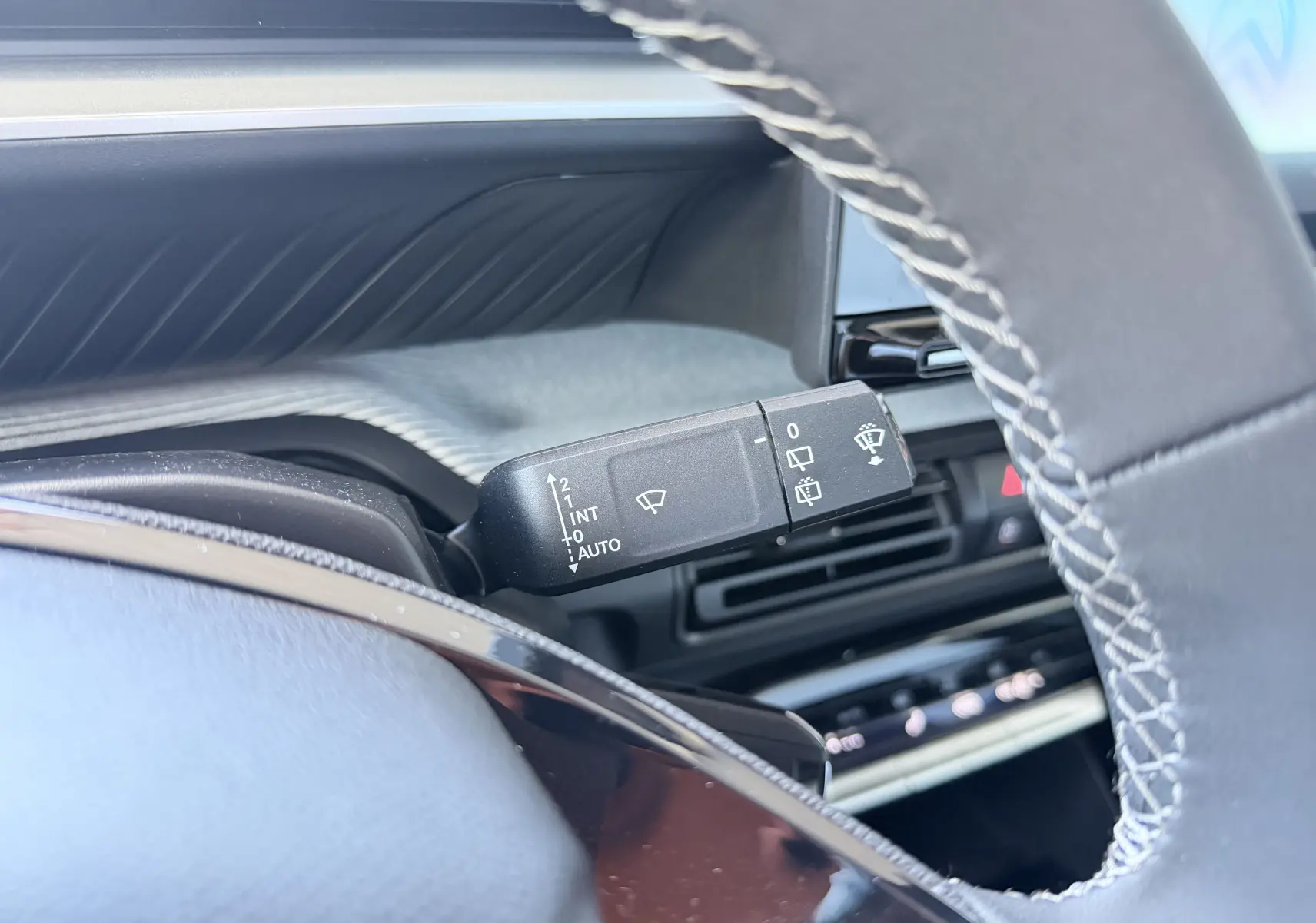 Gros plan sur la commande des essuie-glaces côté gauche du volant d'une Citroën C3 E-C3 113 MAX 2025, intérieur noir.
