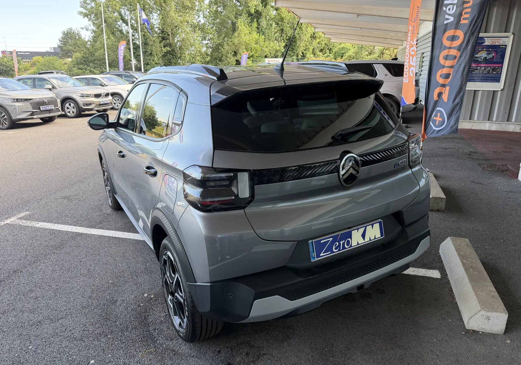 Vue 3/4 arrière droite d'une Citroën E-C3 113 MAX gris Mercury avec vitres arrière surteintées et jantes alliage 17 pouces.