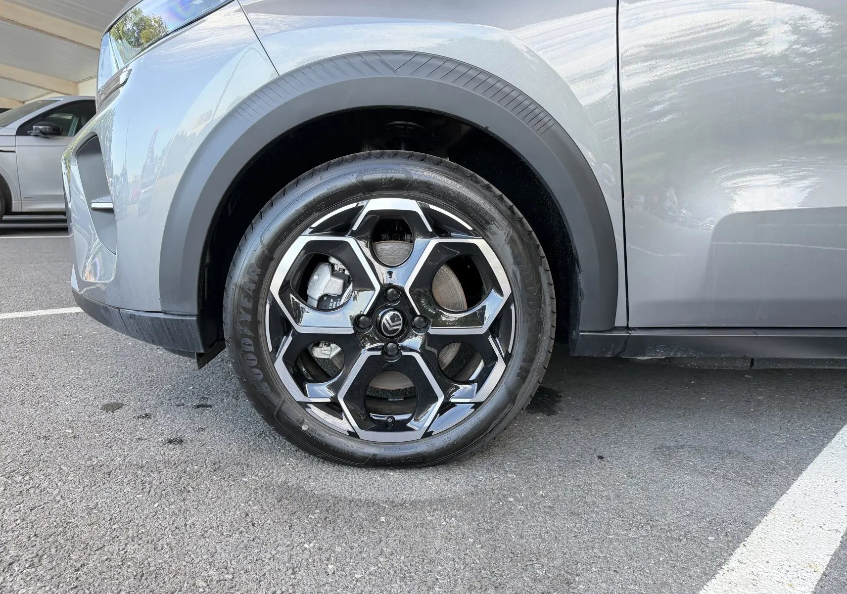 Gros plan sur la roue avant gauche et la carrosserie gris Mercury d'une Citroën E-C3 113 MAX avec jante alliage 17 pouces.