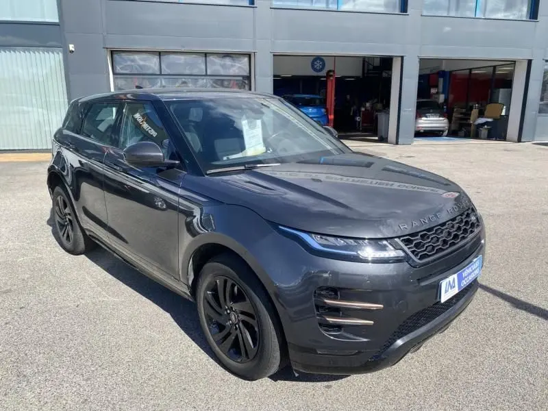 Range Rover Evoque gris foncé métal vu en 3/4 avant droit, avec jantes noires et calandre distinctive.