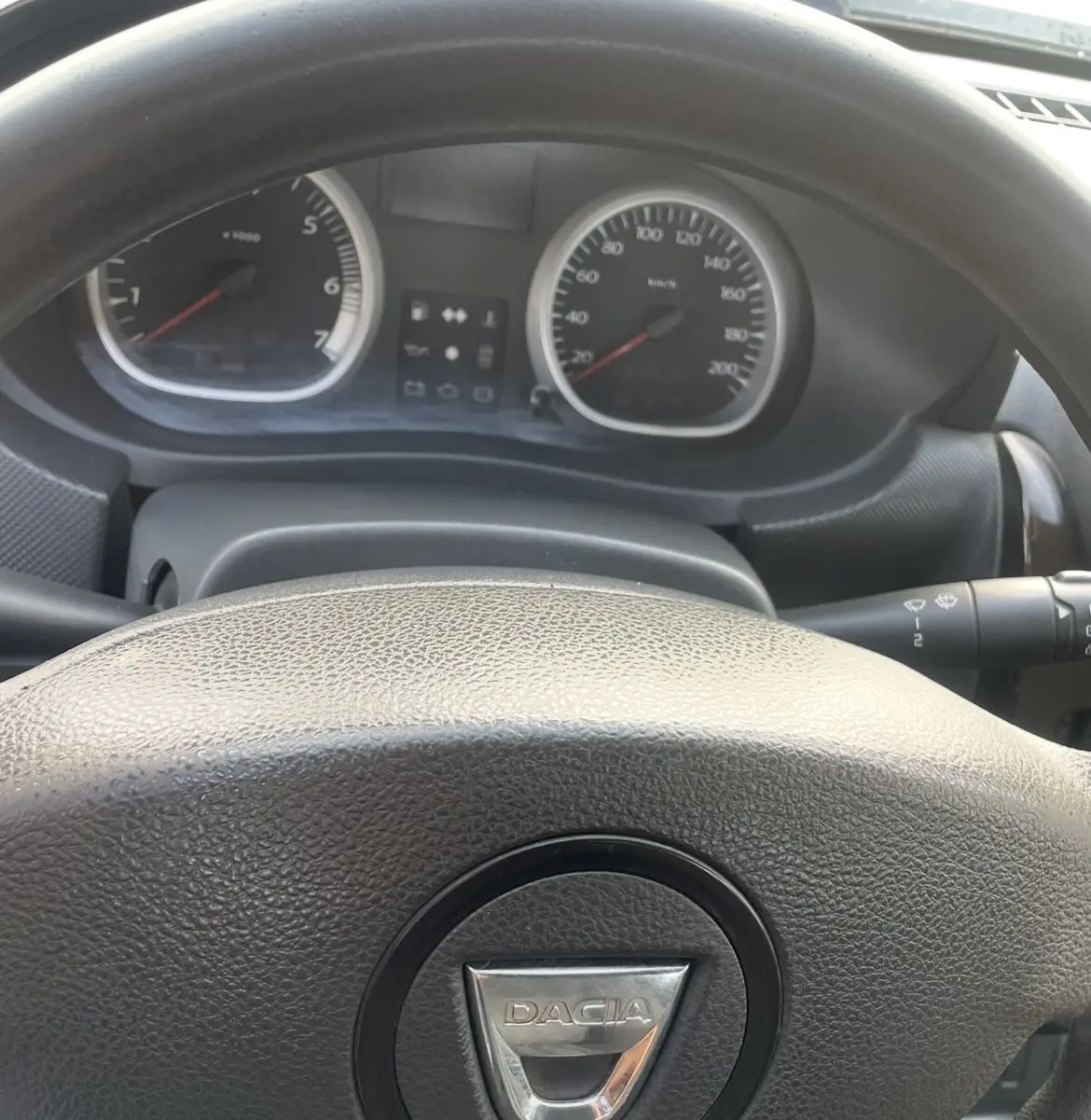 Vue rapprochée du tableau de bord et du volant noir du Dacia Duster 2011 avec compte-tours et compteur de vitesse.