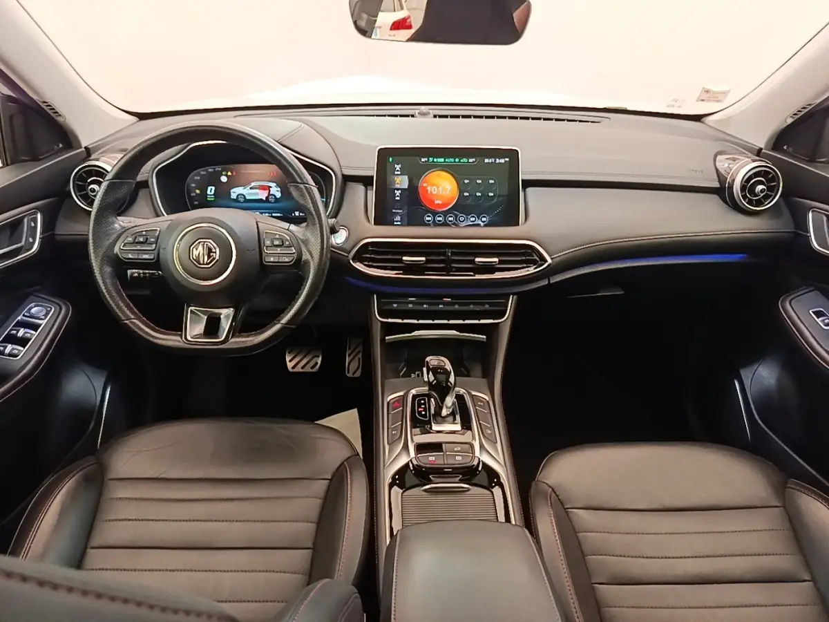 Vue intérieure frontale du tableau de bord et volant MG EHS 2023, avec écran tactile central et finitions cuir noires.