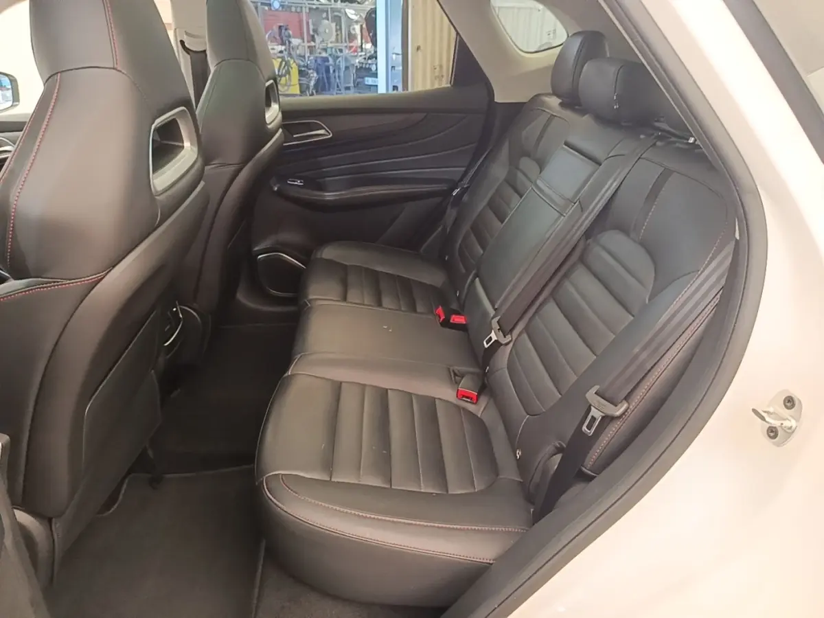 Vue intérieure côté droit sur la banquette arrière en cuir noir avec surpiqûres rouges du MG MOTOR EHS blanc 2023.