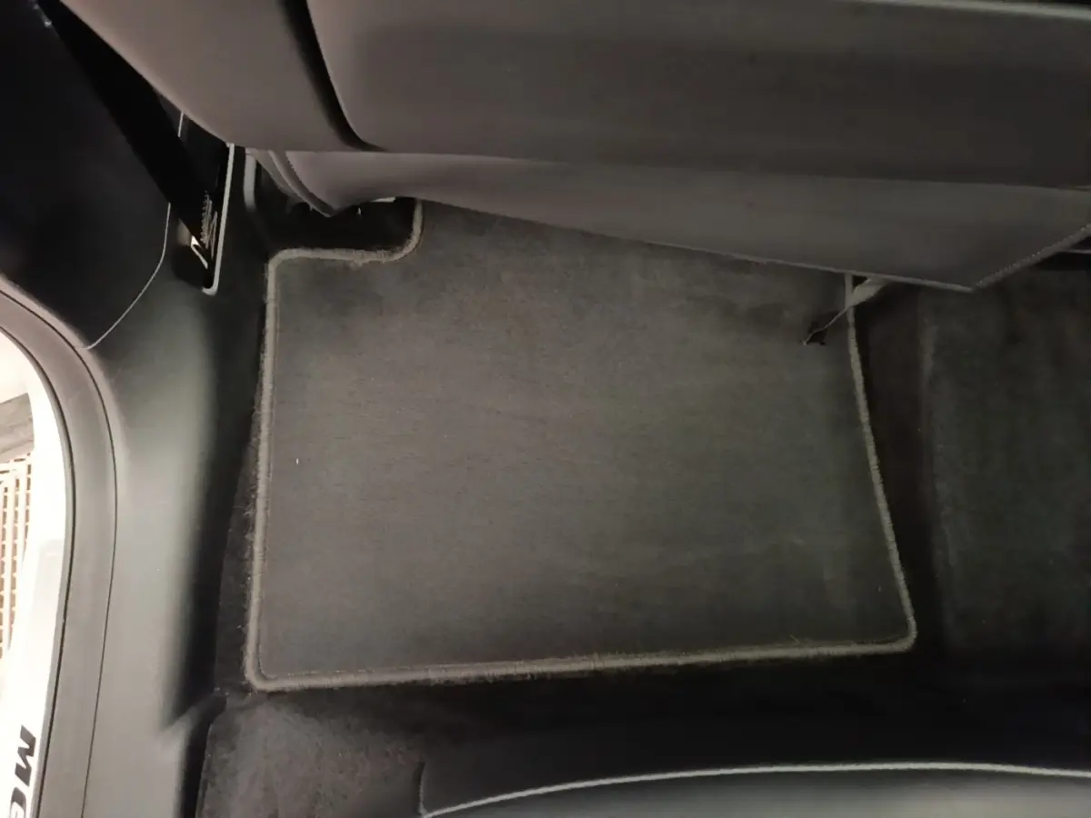 Tapis de sol gris foncé côté passager arrière dans l’habitacle du MG MOTOR EHS blanc hybride rechargeable.