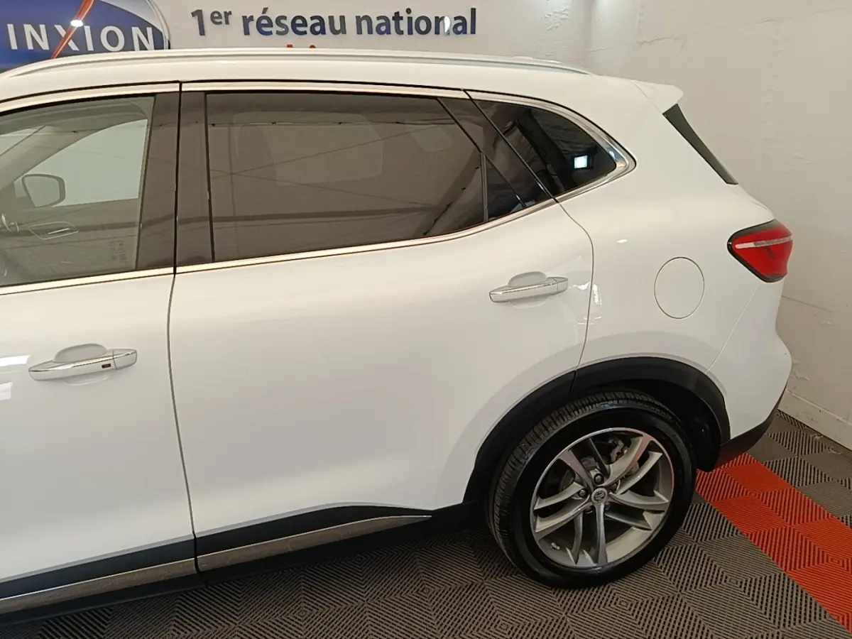 Vue latérale droite du MG MOTOR EHS blanc 2023, mettant en valeur les jantes alliage et les vitres teintées.