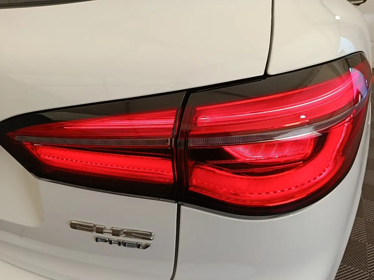Gros plan sur le feu arrière droit rouge du MG MOTOR EHS blanc 2023 avec logo EHS PHEV visible sur la carrosserie.