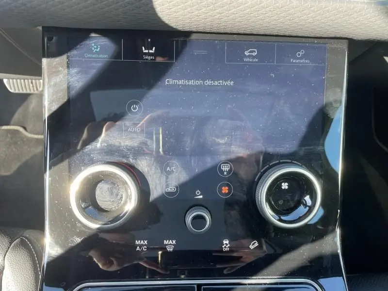Panneau de commande central tactile du Range Rover Velar 2020 gris métal, affichant la climatisation désactivée.