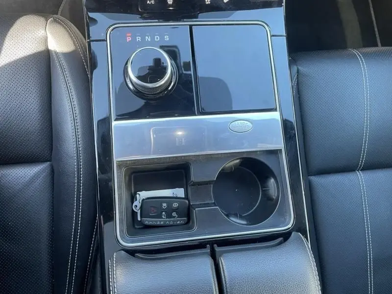 Vue rapprochée de la console centrale noire du Range Rover Velar 2020 avec molette de boîte auto et clé posée.