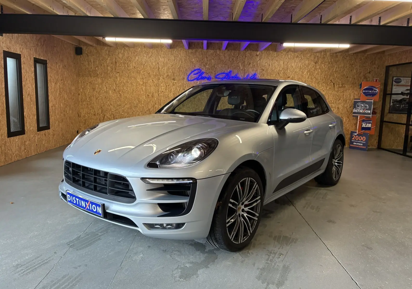 Vue 3/4 avant gauche d'une Porsche Macan GTS 2017 argent avec jantes RS Spyder 20 pouces en intérieur showroom.