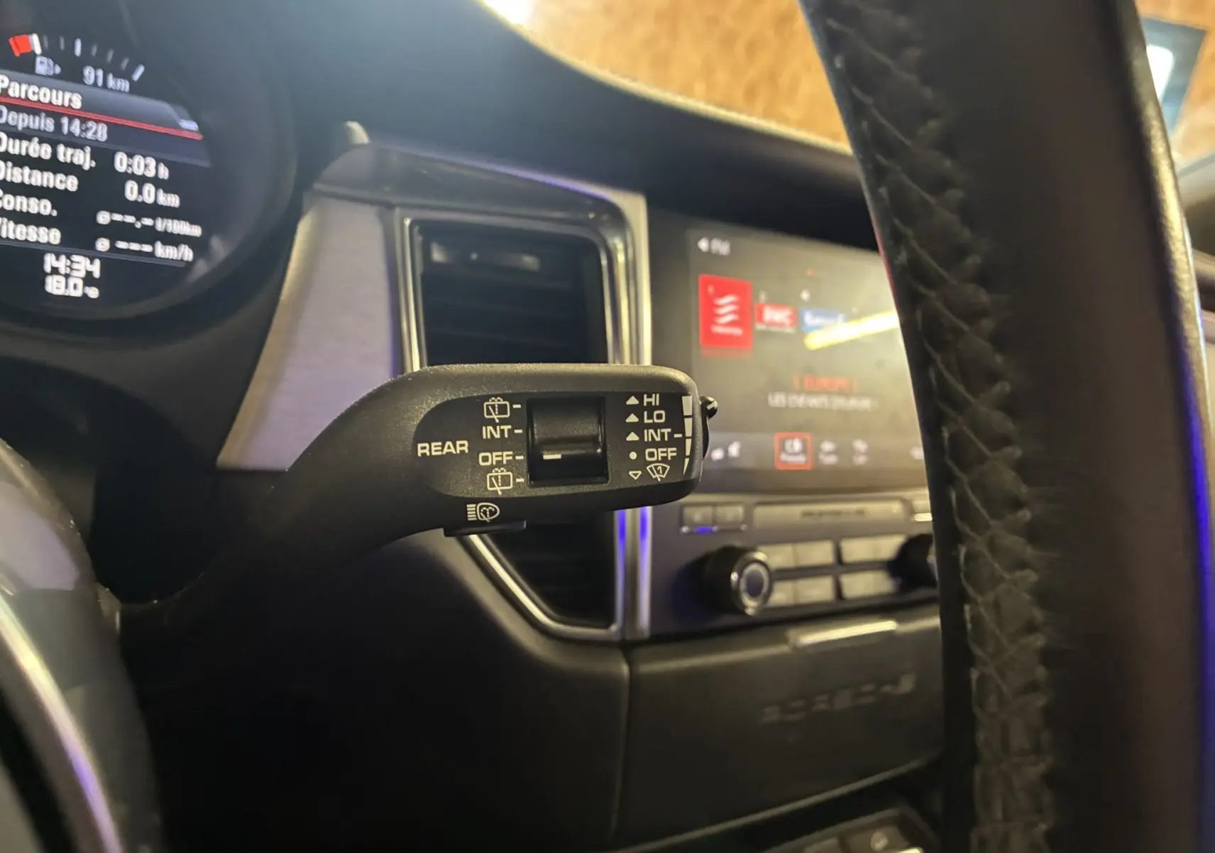 Gros plan sur la commande d'essuie-glace à gauche du volant dans l'habitacle noir du Porsche Macan GTS 2017.