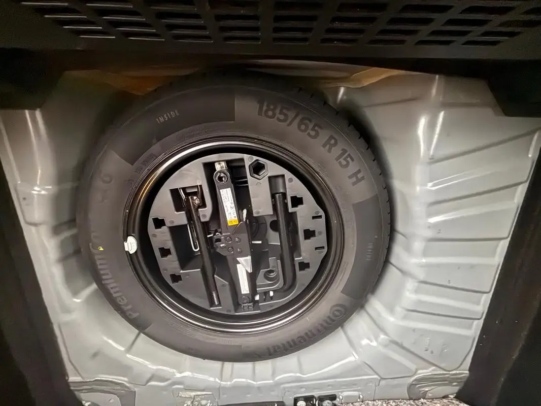 Roue de secours et outillage rangés dans le coffre d'une Renault Clio gris foncé V TCe 90 Equilibre 2022.