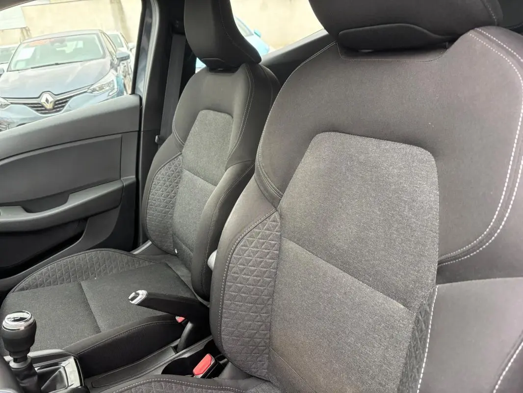 Intérieur de la Renault Clio V TCe 90 Equilibre 2022, vue côté droit sur les sièges tissu gris foncé et levier de vitesse manuel.