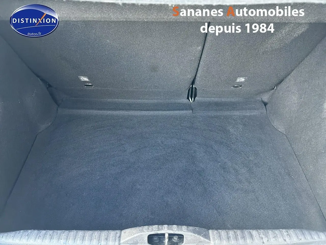 Coffre spacieux vu de face, revêtement intérieur gris foncé, sans objet ni accessoire visible.