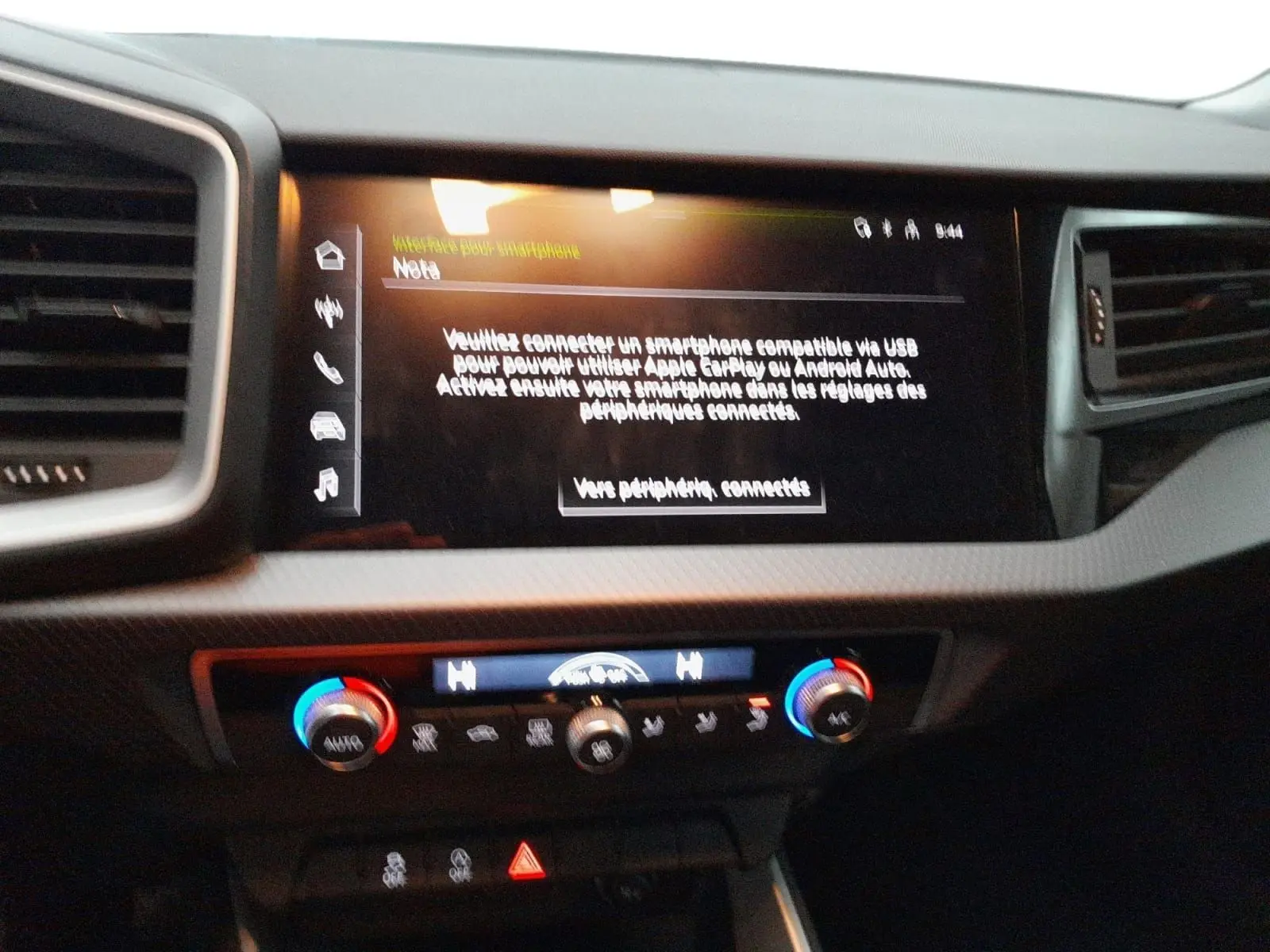 Vue rapprochée de la console centrale de l'Audi A1 Sportback 2023 avec écran tactile et commandes de climatisation bicolores.