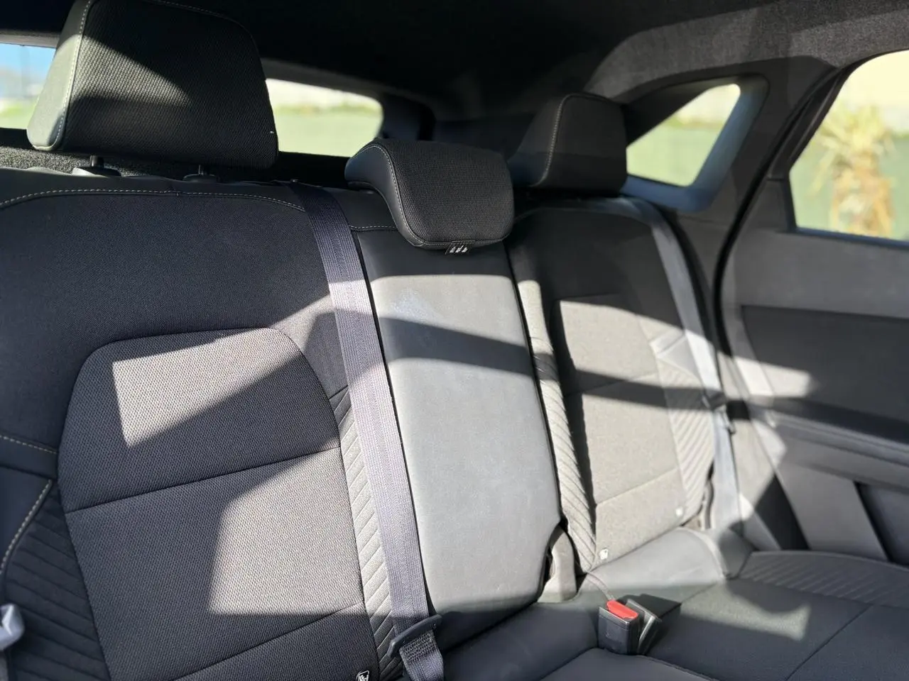 Vue intérieure de la banquette arrière du Renault SYMBIOZ gris, avec appuie-têtes et ceintures visibles.