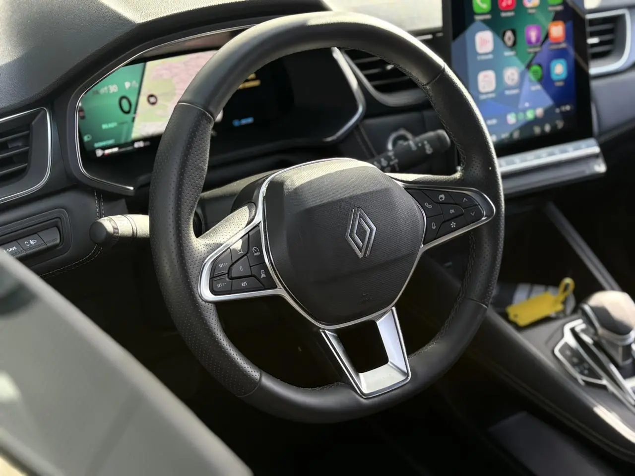 Vue rapprochée du volant noir en cuir du Renault SYMBIOZ 2025 avec tableau de bord numérique et écran tactile central.