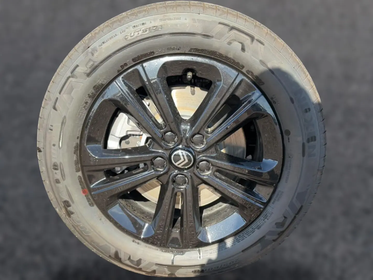 Gros plan sur la jante alu noire avec logo Citroën au centre, montée sur un pneu Nexen.