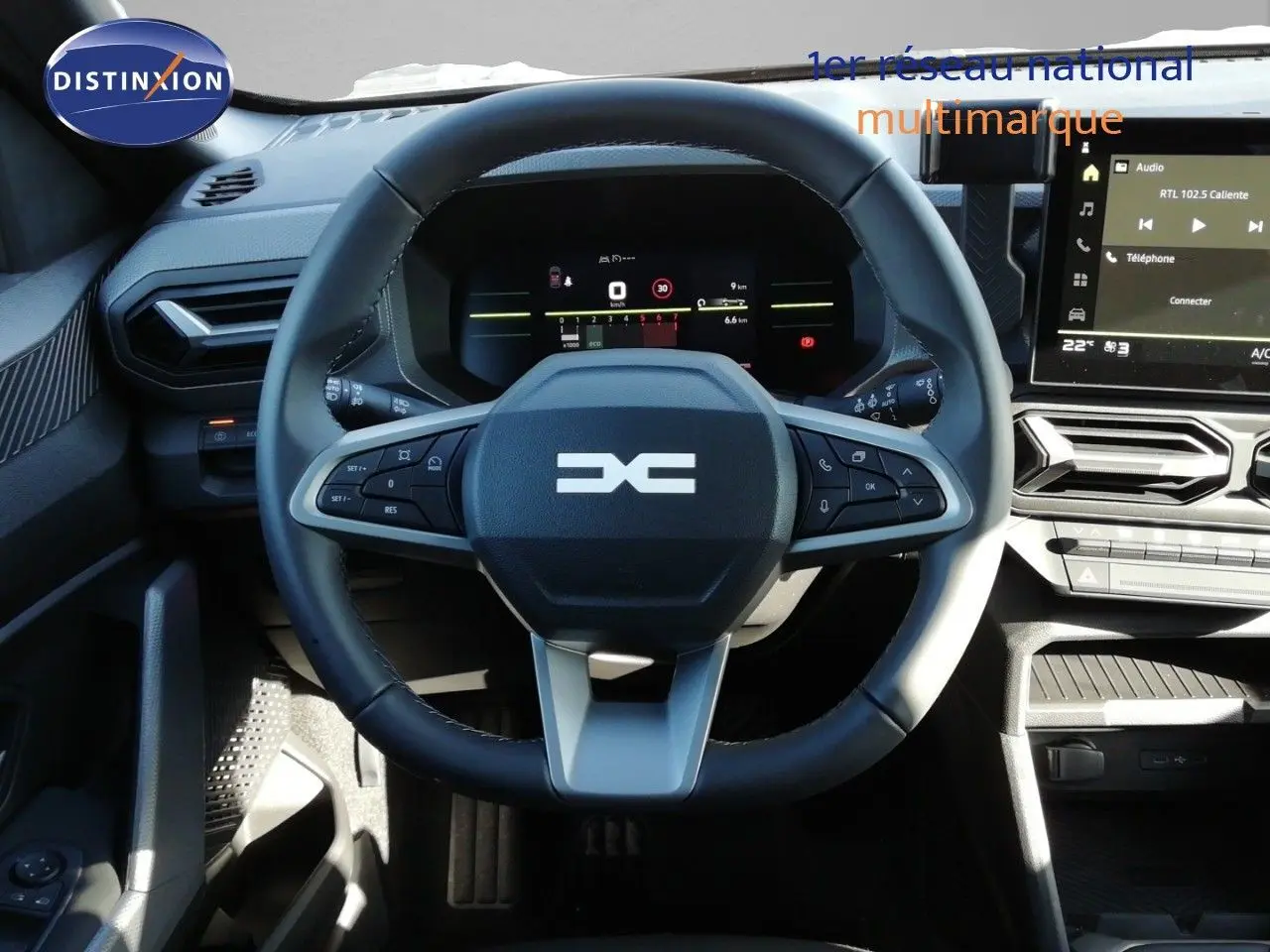 Vue rapprochée du volant multifonction et du tableau de bord numérique d’un Dacia Duster 2026, intérieur gris noir.