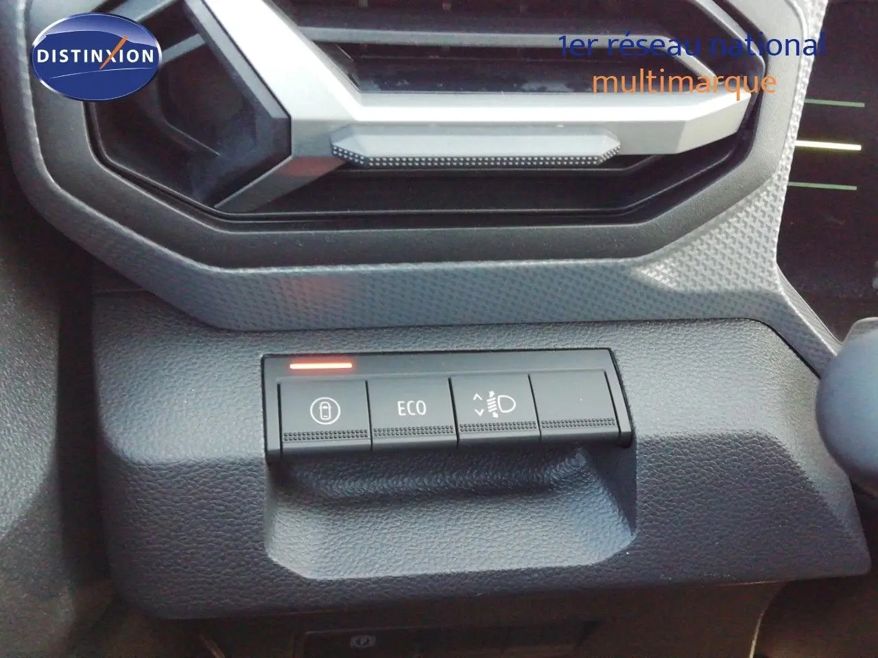 Gros plan sur les commandes de tableau de bord du Dacia Duster TCE MHEV 140ch Journey, boutons ECO et phares visibles.