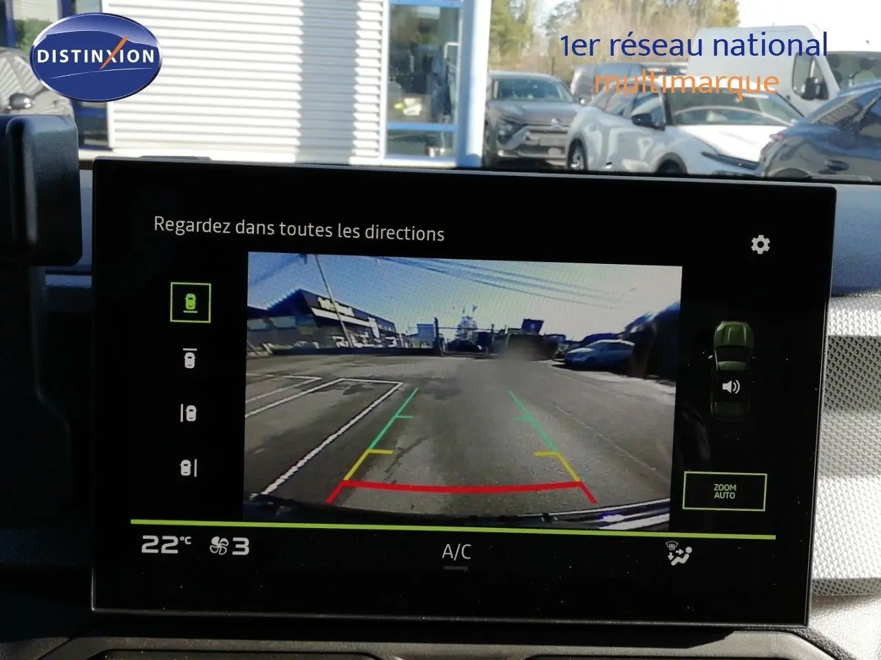 Écran central du Dacia Duster 2026 gris schiste montrant la caméra de recul avec lignes de guidage colorées.
