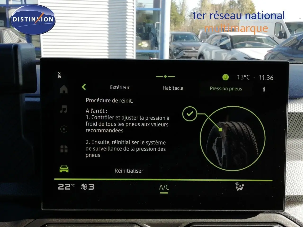 Écran central du tableau de bord d’un Dacia Duster gris schiste métal, affichant la procédure de réinitialisation de la pression des pneus.
