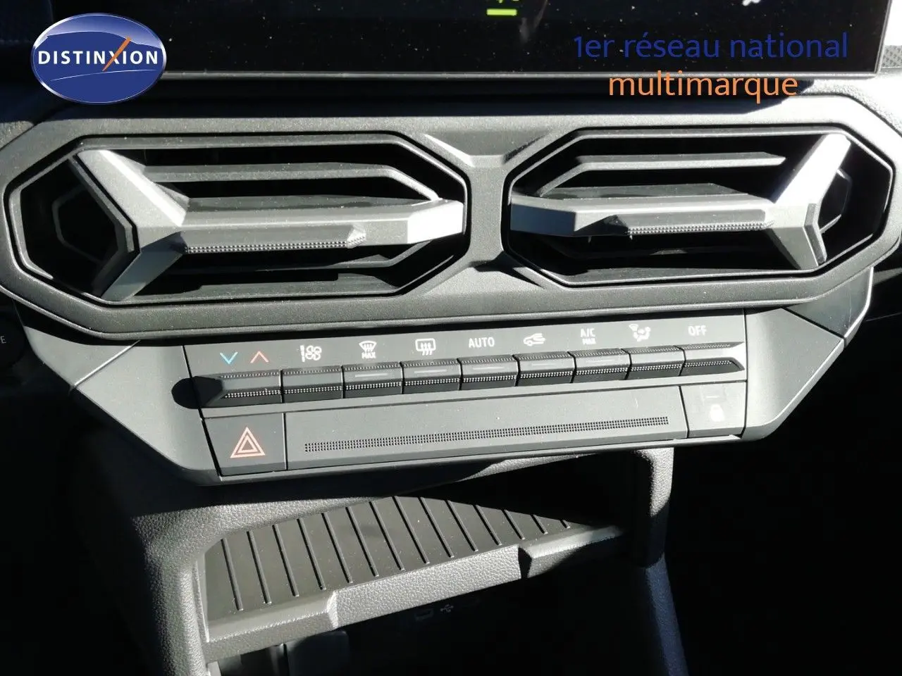 Vue rapprochée des commandes de climatisation et des aérateurs hexagonaux noirs du Dacia Duster gris schiste métal.