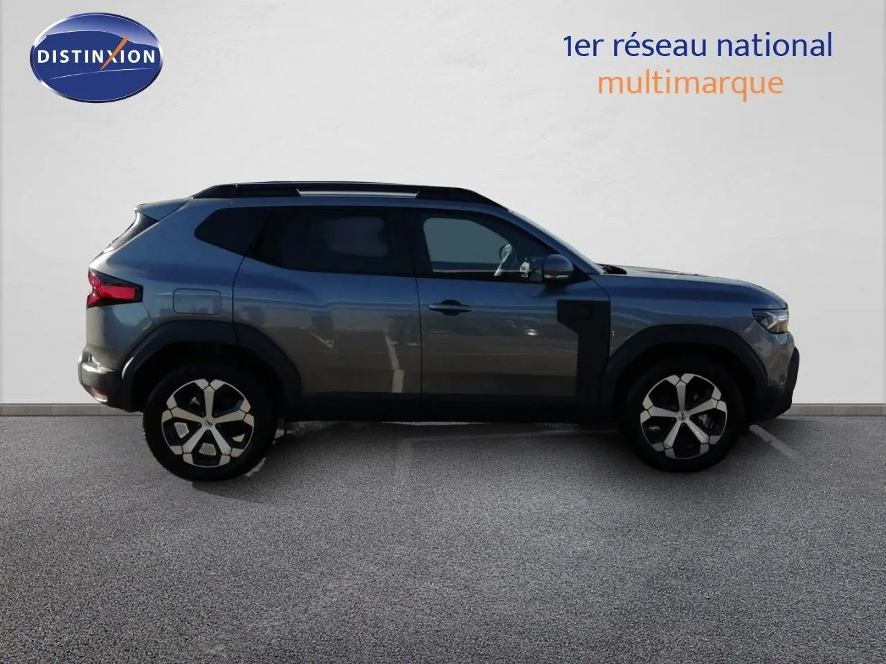 Profil droit du Dacia Duster TCE MHEV 140ch Journey gris schiste métal, avec jantes bi-ton et protections noires.