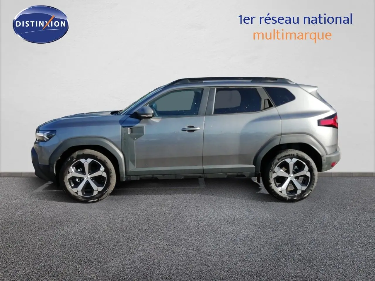 Vue de profil côté gauche du Dacia Duster TCE MHEV 140ch Journey gris schiste métal avec jantes alliage bicolores.
