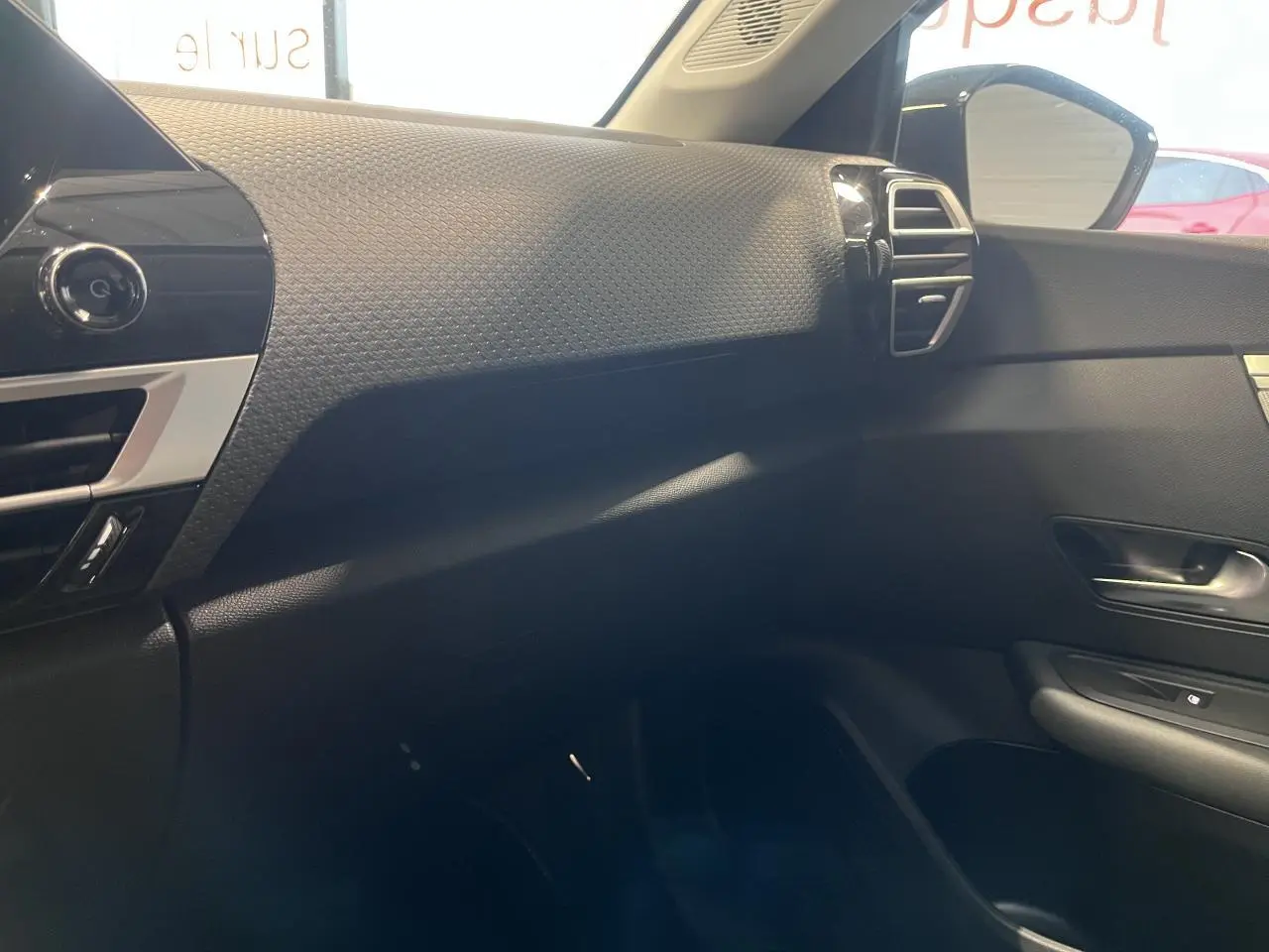 Vue intérieure côté passager de la planche de bord noire texturée avec aérateur argenté d'une Citroën C4 2025.