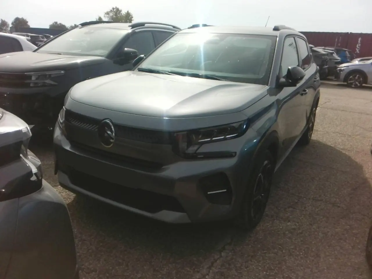 Citroën C3 Turbo 100 Max gris Mercury vue 3/4 avant droit, avec barres de toit noir brillant et jantes alliage.