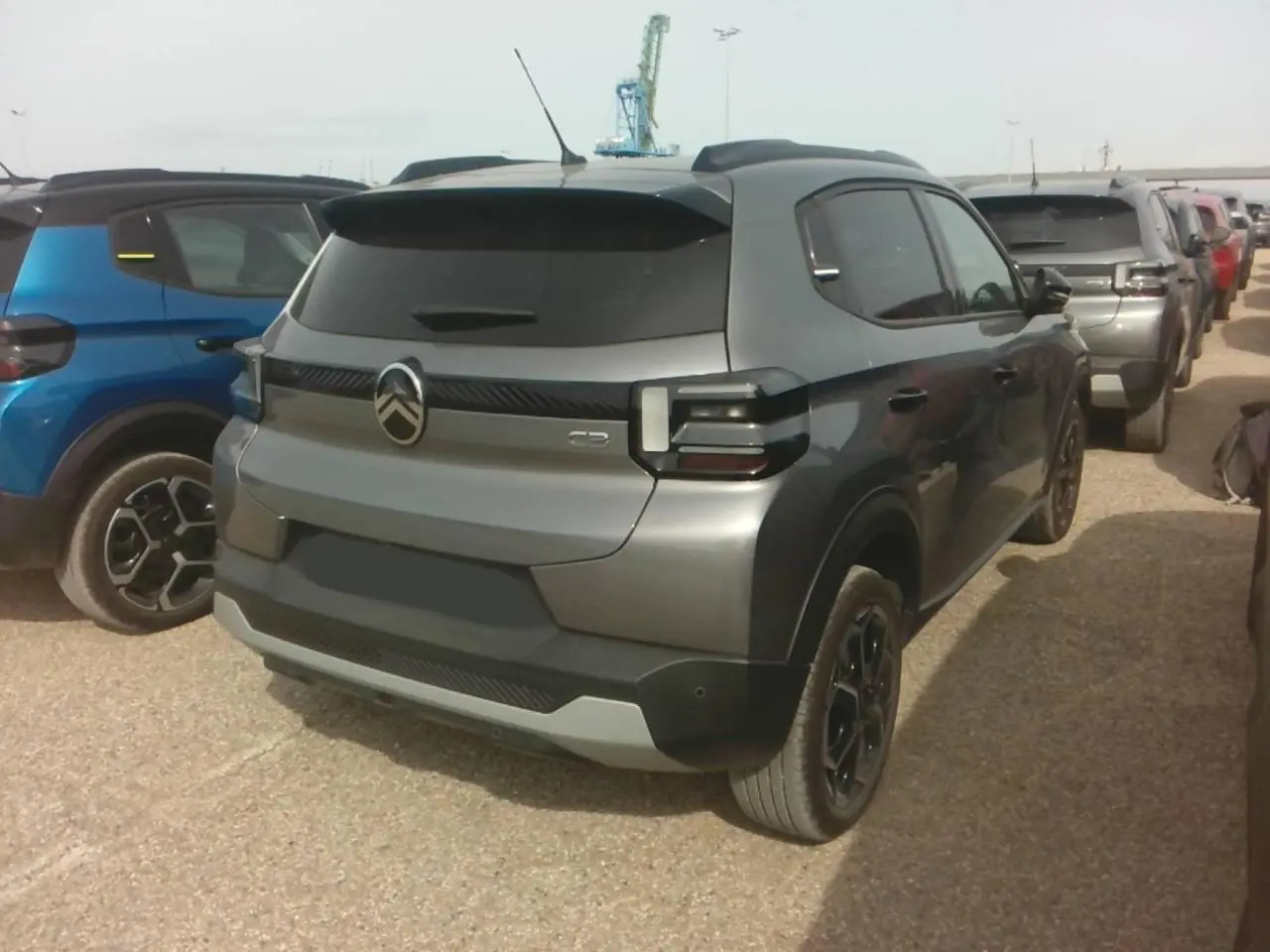 Vue 3/4 arrière droite d'une Citroën C3 Turbo 100 Max gris Mercury avec vitres arrière surteintées et jantes noires.