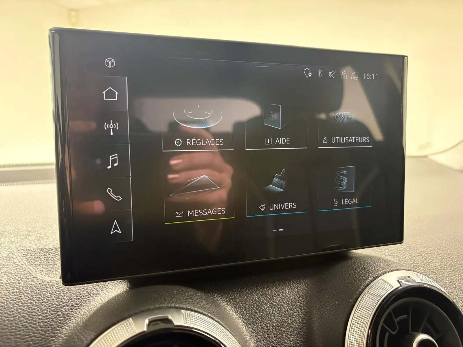 Vue intérieure du tableau de bord de l'Audi Q2 35 TFSI S Line 2026 avec écran tactile central et aérateurs ronds.