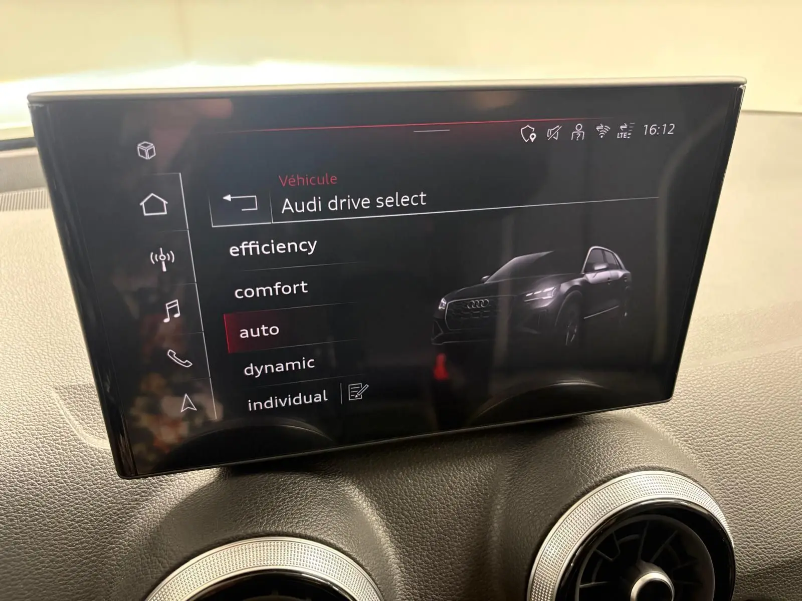 Écran central intérieur affichant le menu Audi drive select avec une image numérique du SUV Audi Q2 en vue 3/4 avant.