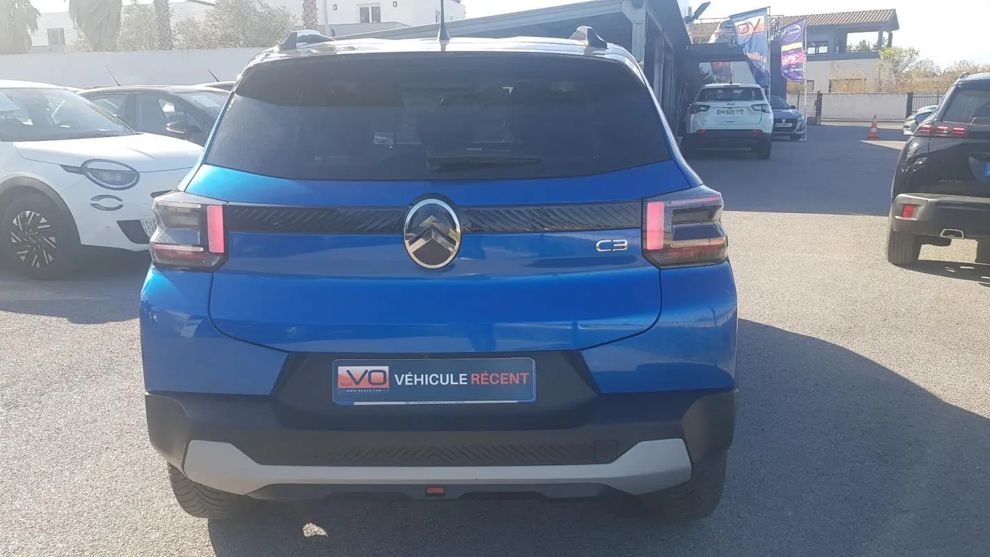 Vue arrière d'une Citroën C3 bleu foncé 2024 avec barres de toit et feux arrière à LED distinctifs.