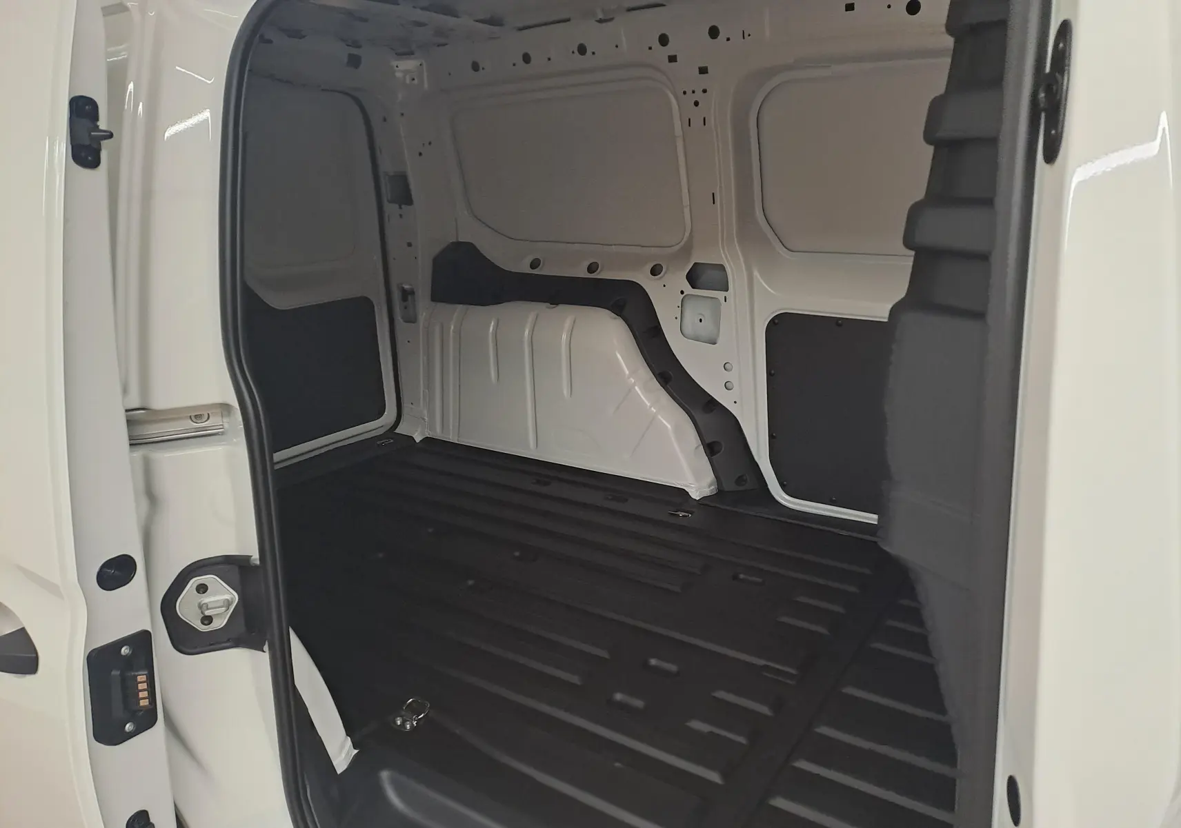 Vue intérieure du coffre côté droit du Volkswagen Caddy Cargo Maxi blanc Candy, montrant l'espace de chargement vide.
