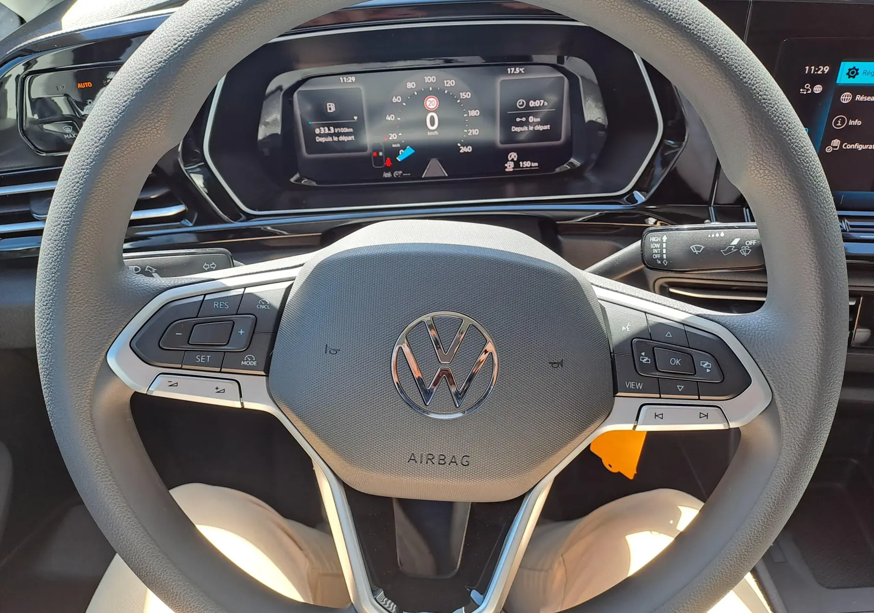 Vue intérieure centrée sur le volant gris du Volkswagen Caddy 2026 avec tableau de bord numérique et commandes intégrées.