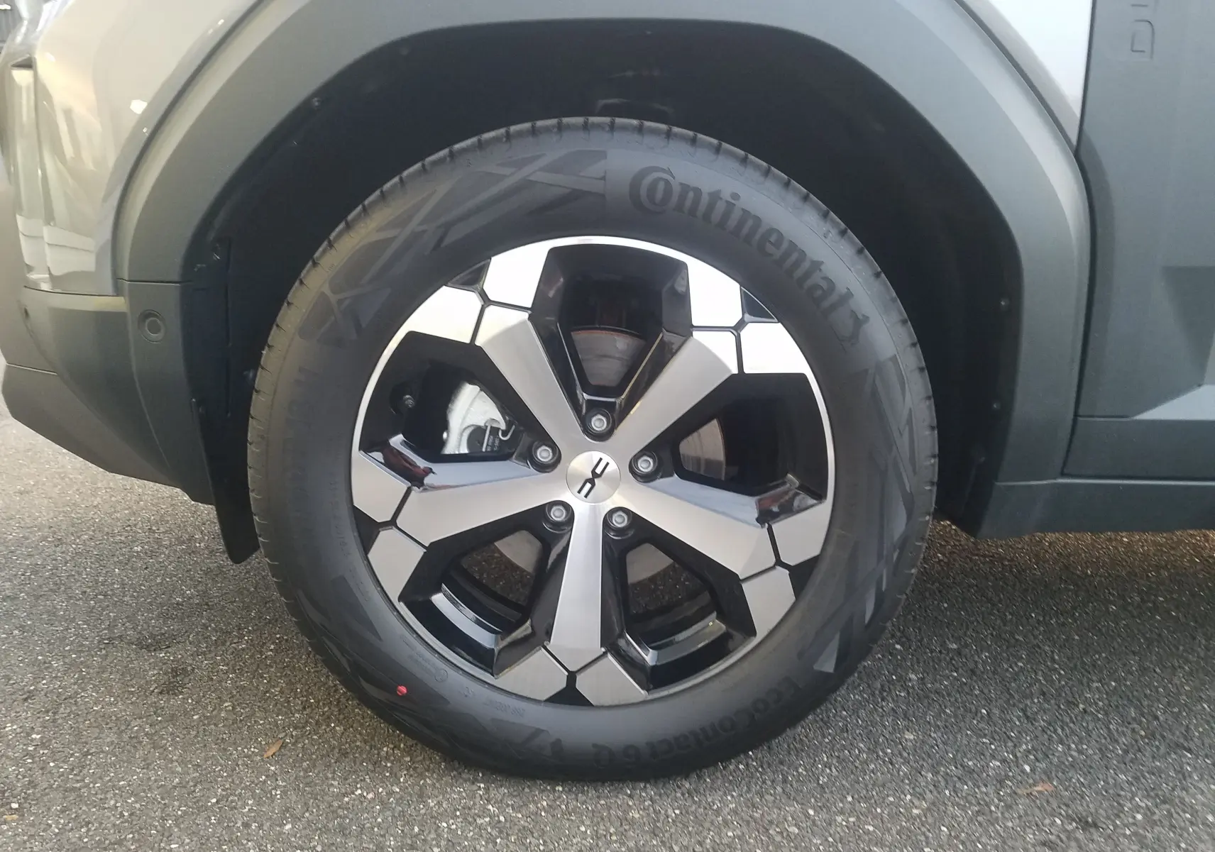 Gros plan sur la roue avant gauche du Dacia Duster gris schiste, mettant en valeur la jante 18 pouces au design moderne.