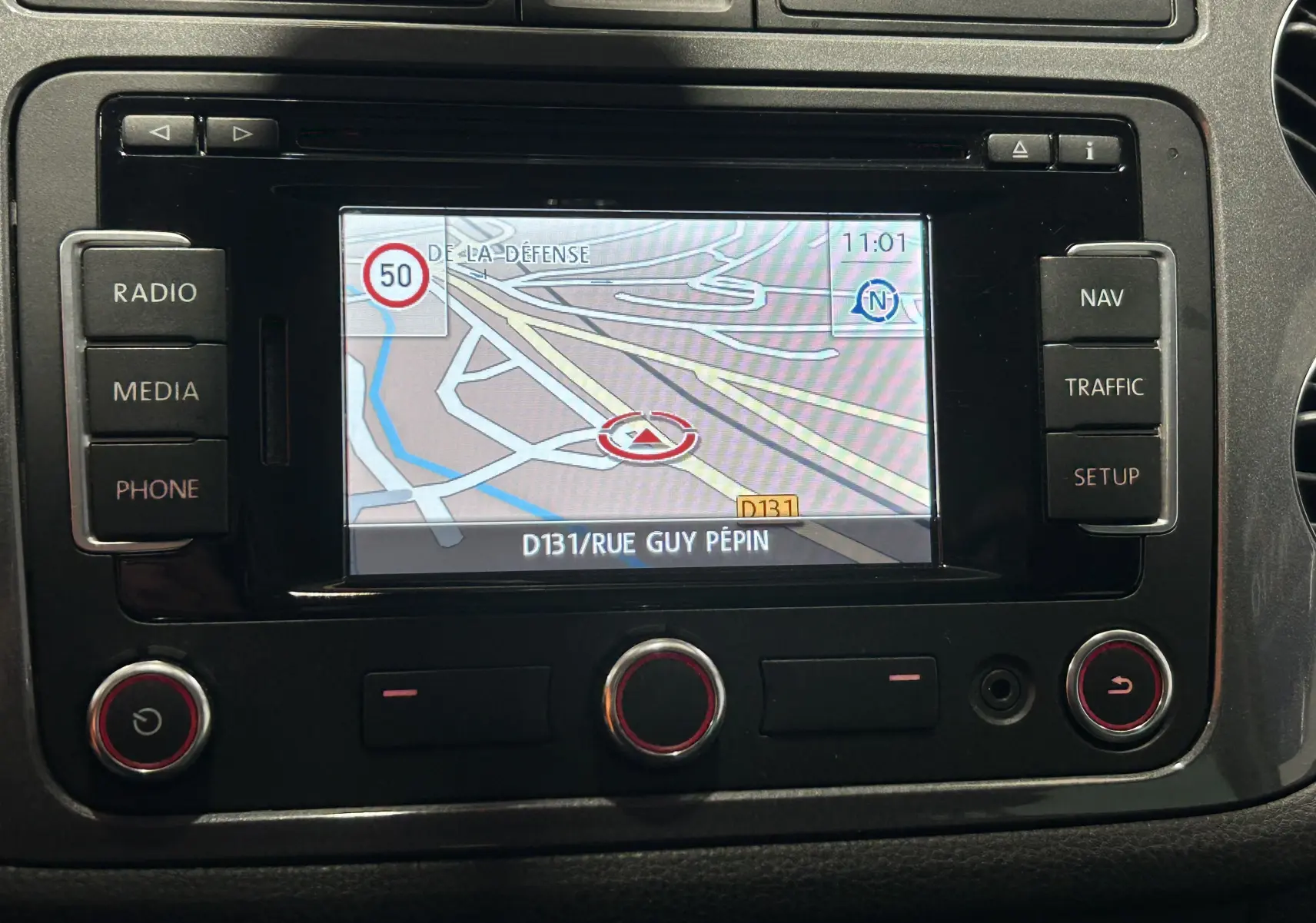 Écran GPS du tableau de bord du Volkswagen Tiguan 2015 affichant une carte et les commandes autour.