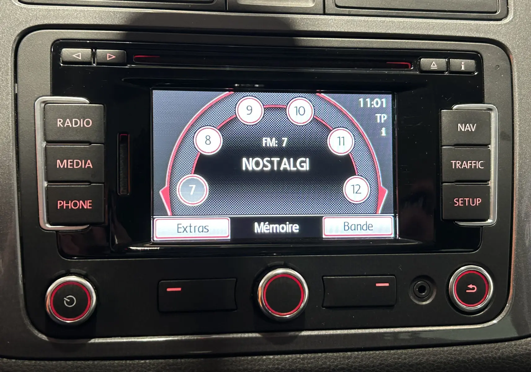 Écran central multimédia de Volkswagen Tiguan 2015 affichant la radio FM sur fond noir avec boutons autour.