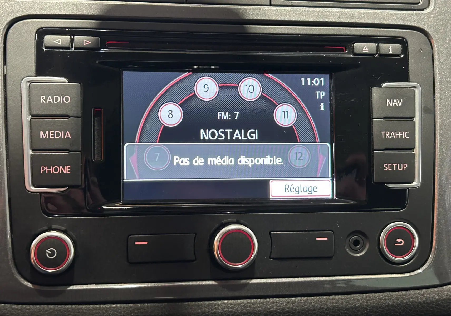 Écran central multimédia du Volkswagen Tiguan 2015 avec affichage radio et boutons de commande noirs.