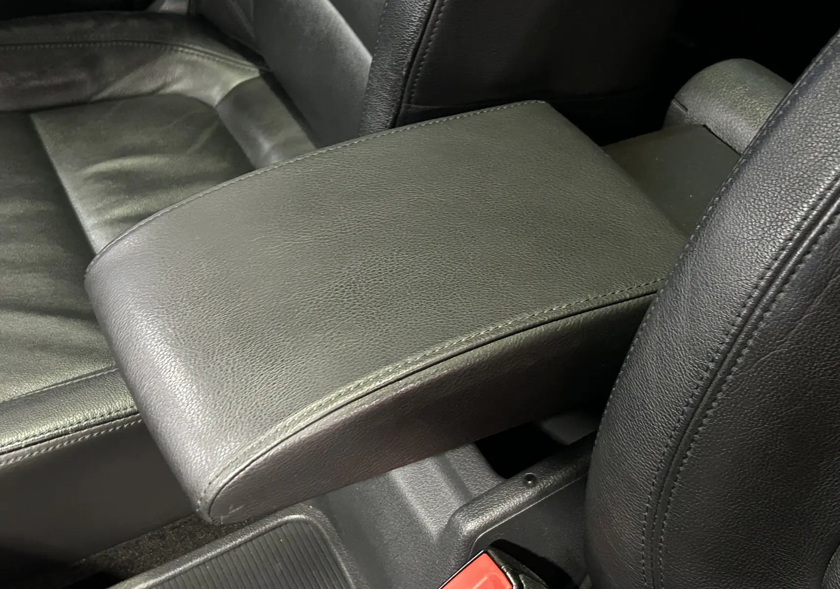 Gros plan sur l'accoudoir central en cuir noir entre les sièges avant du Volkswagen Tiguan 2015.