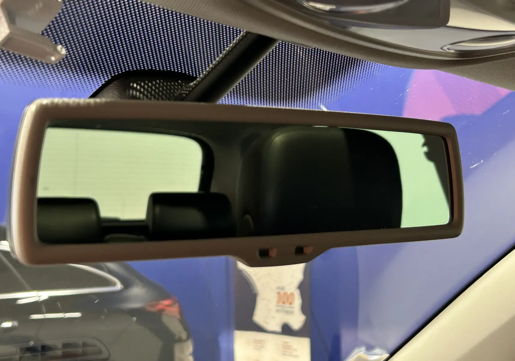 Rétroviseur intérieur reflétant les appuie-têtes noirs du Volkswagen Tiguan noir métal, vue depuis l'avant intérieur.